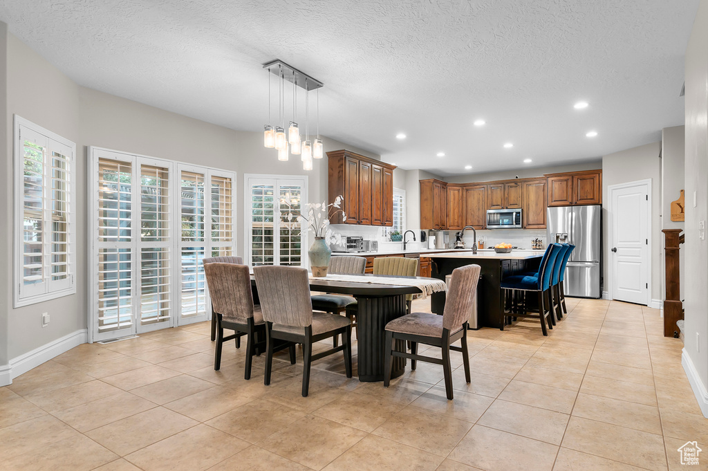 Dining room featuring recessed lighting, a textured ceiling, and light tile patterned flooring