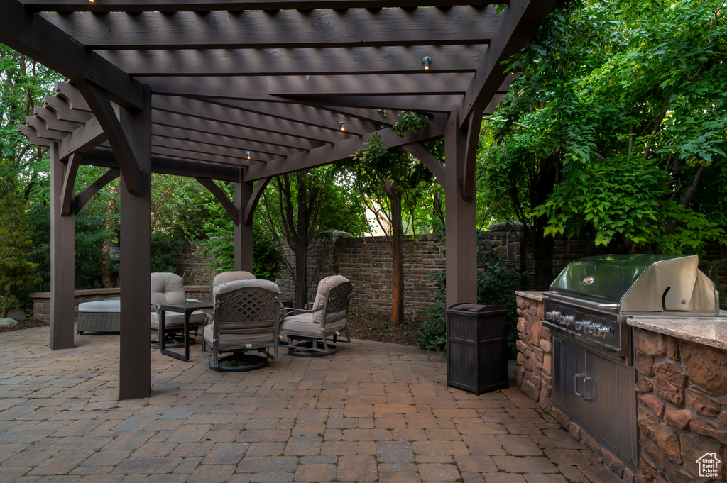 View of patio featuring a pergola and an outdoor kitchen