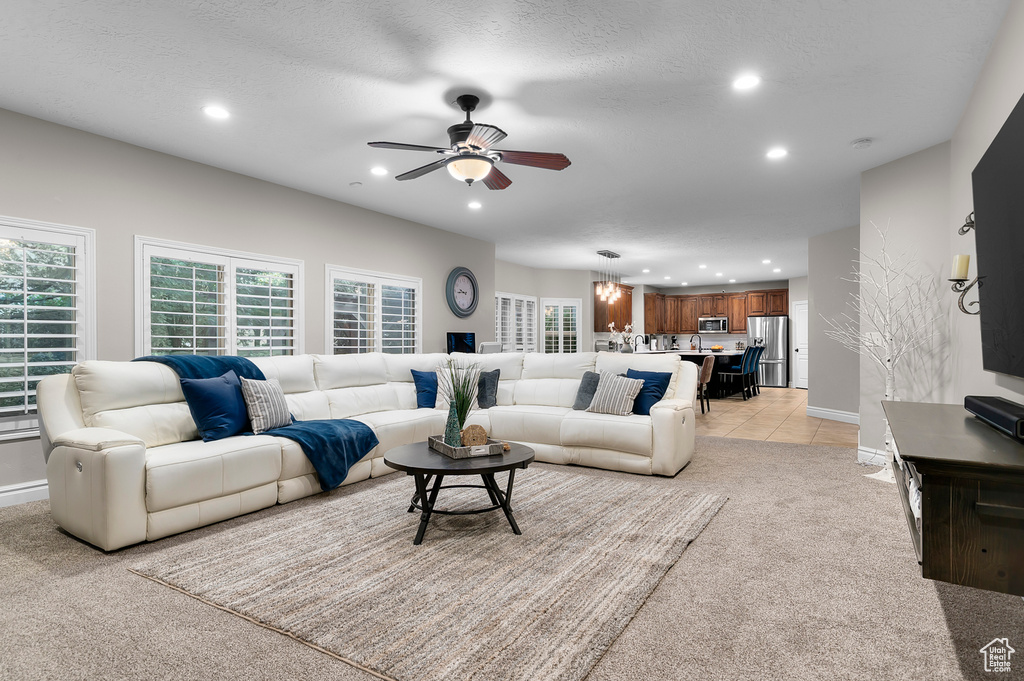 Living room with a ceiling fan, recessed lighting, and light colored carpet