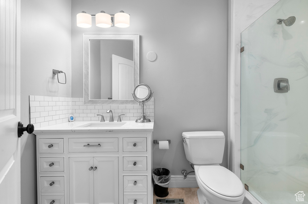 Bathroom featuring decorative backsplash, vanity, a stall shower, and tile patterned flooring