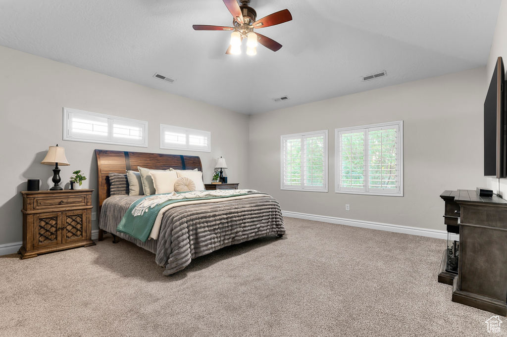 Bedroom featuring carpet floors, lofted ceiling, and a ceiling fan