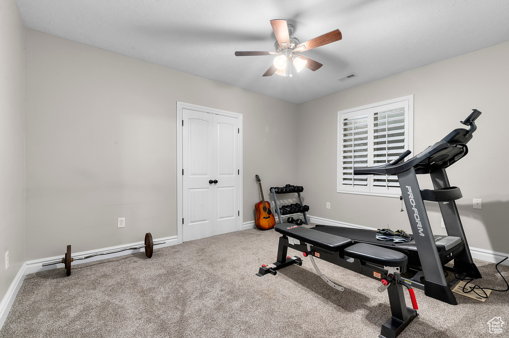 Workout area featuring a ceiling fan and carpet