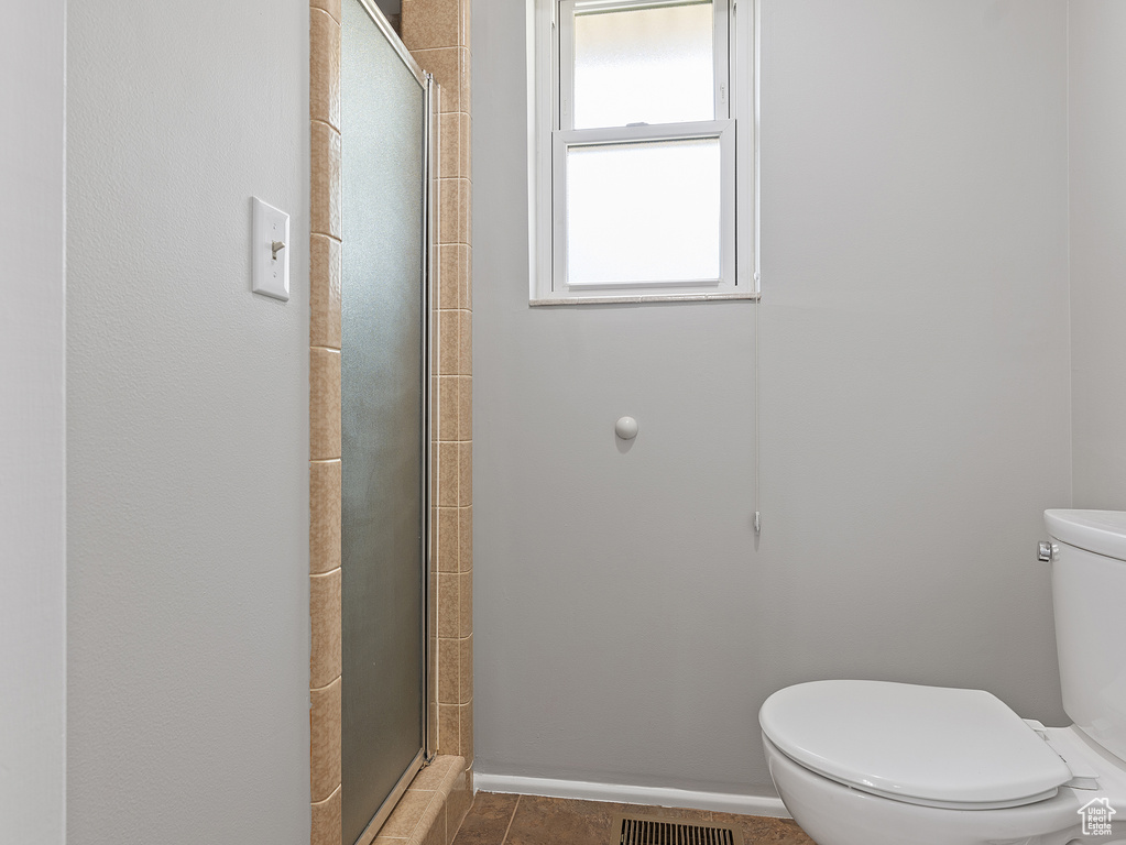 Bathroom with toilet and tiled shower