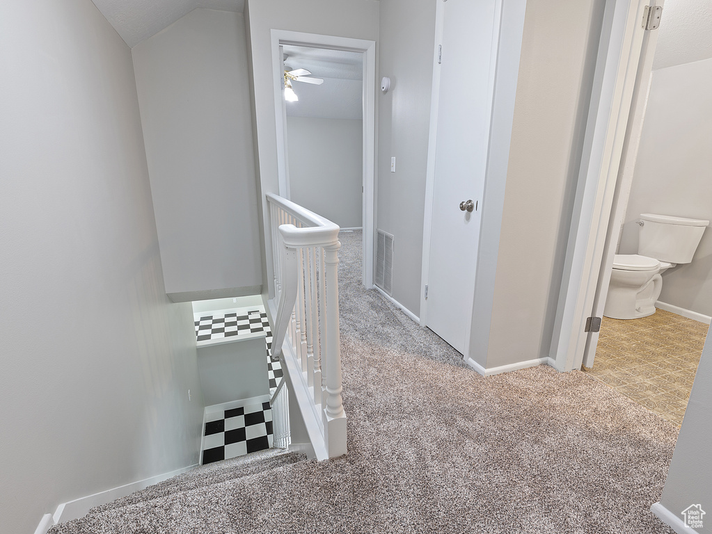 Stairway with carpet and a ceiling fan