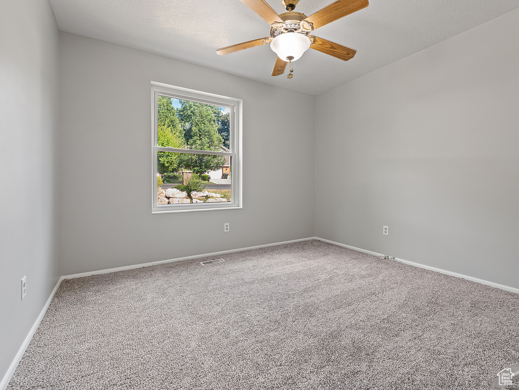 Empty room featuring carpet and a ceiling fan