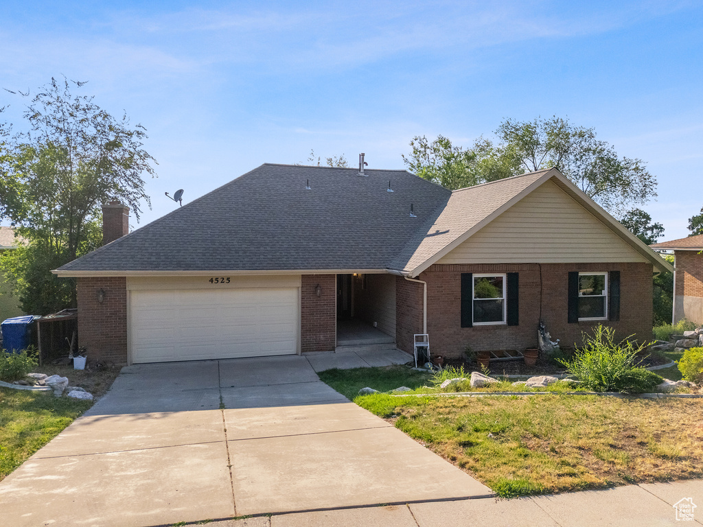 Ranch-style home with brick siding, concrete driveway, a chimney, an attached garage, and a shingled roof