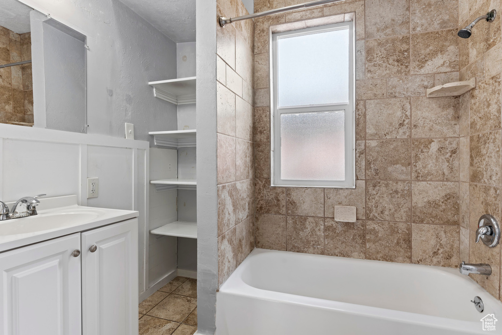 Full bath with vanity, tile patterned floors, and shower / tub combination