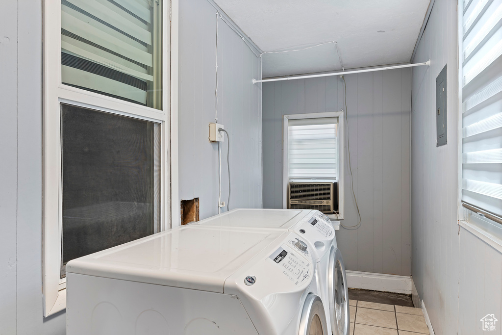 Washroom with separate washer and dryer, light tile patterned flooring, baseboards, electric panel, and cooling unit