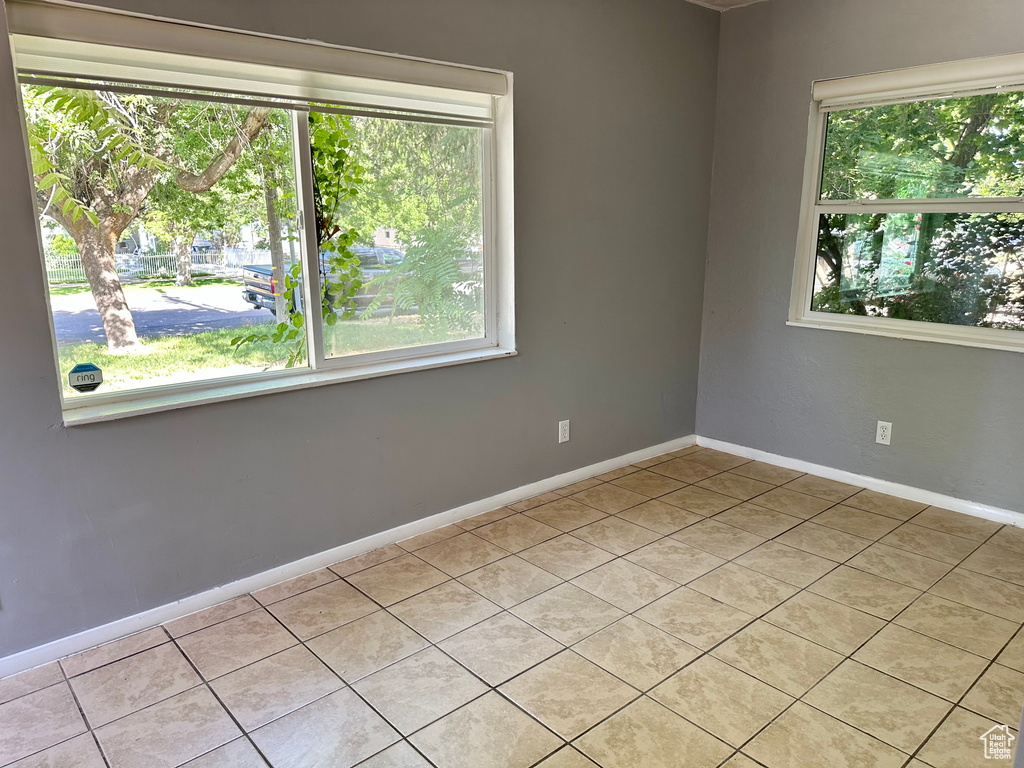 Unfurnished room with plenty of natural light and light tile patterned floors