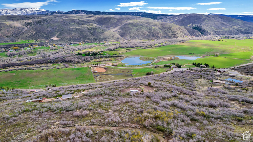 View of mountain background with a nearby body of water and a golf course