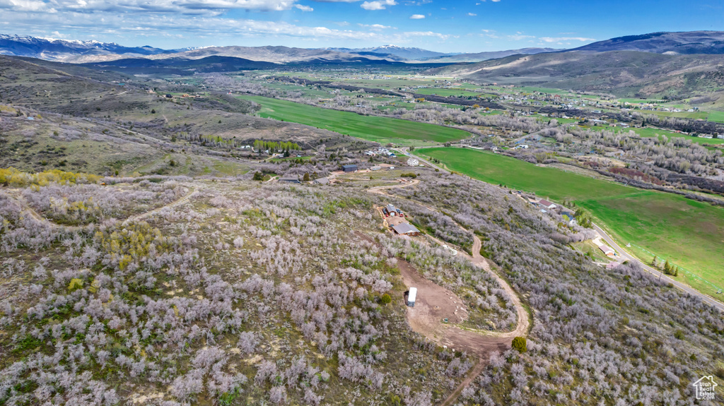 Aerial view of property's location featuring a mountainous background and a golf club
