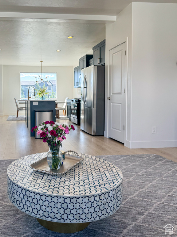 Kitchen featuring stainless steel appliances, light wood-type flooring, a chandelier, hanging light fixtures, and recessed lighting