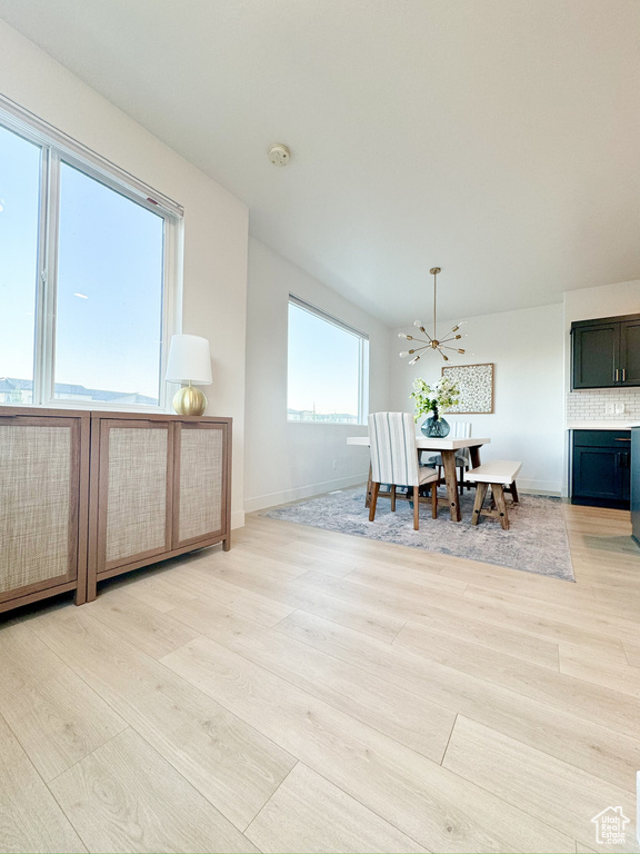 Dining space featuring light wood-style flooring and a chandelier