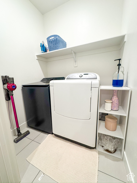Laundry room featuring washer and clothes dryer and tile patterned floors