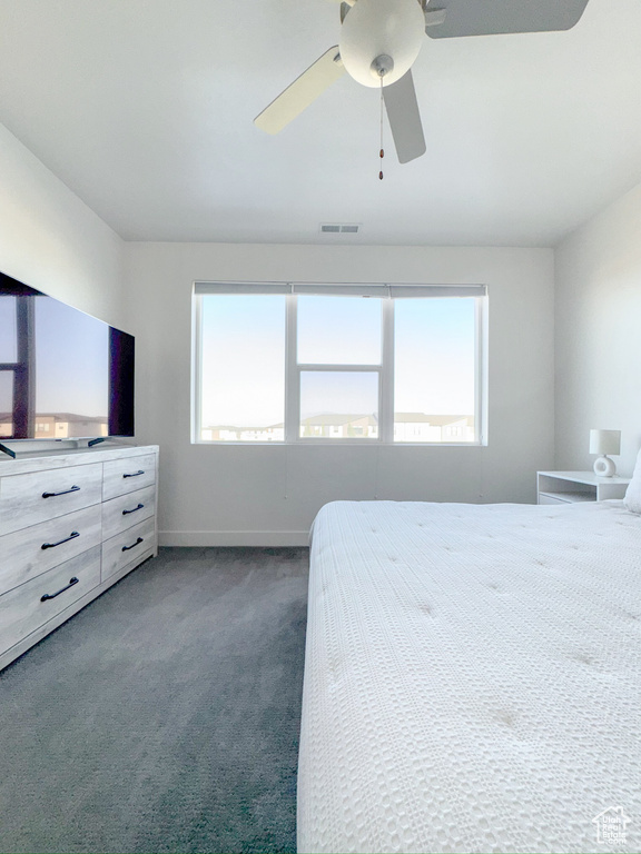 Carpeted bedroom featuring ceiling fan and baseboards