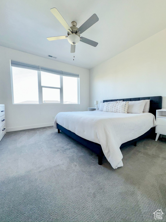 Carpeted bedroom featuring ceiling fan and baseboards