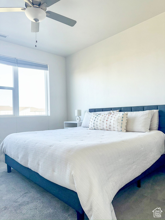 Carpeted bedroom featuring ceiling fan