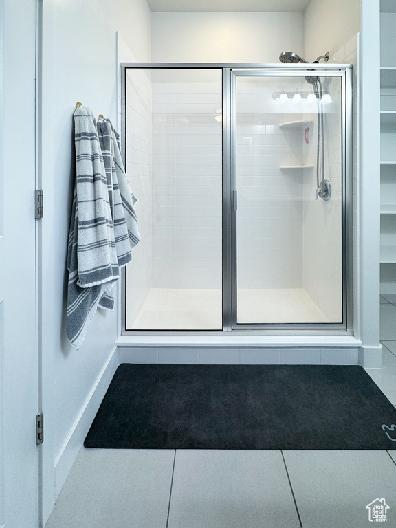 Bathroom with a shower stall and tile patterned floors