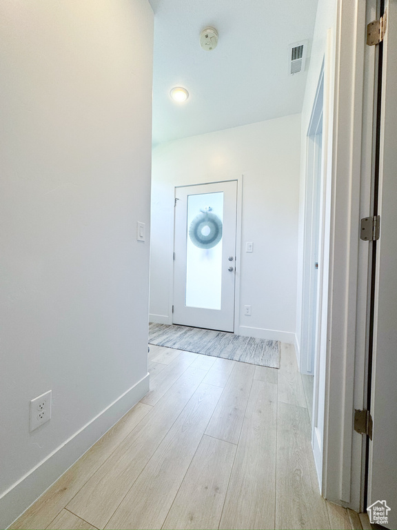 Foyer with light wood finished floors and baseboards