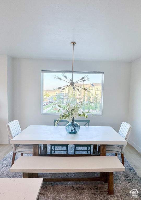 Dining area with wood finished floors and a chandelier