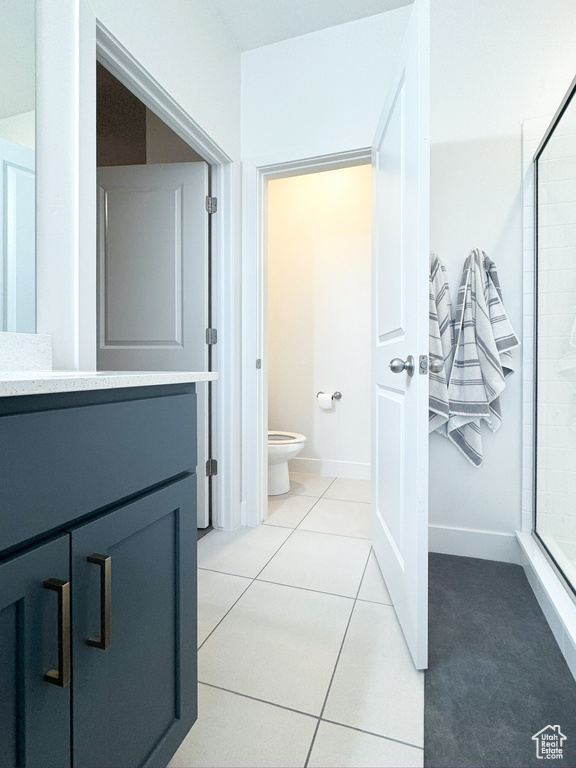 Full bathroom featuring a shower stall, vanity, and tile patterned flooring