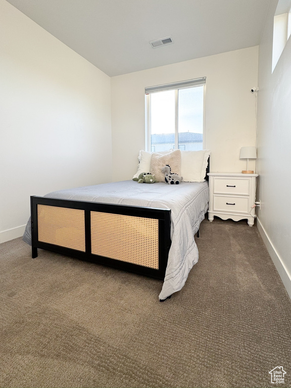 Bedroom featuring dark carpet and baseboards