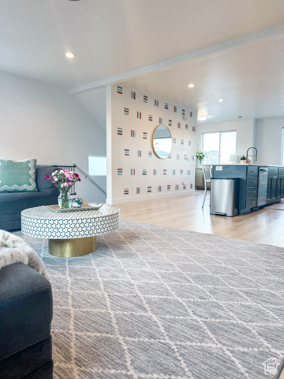 Living area with light wood finished floors and recessed lighting