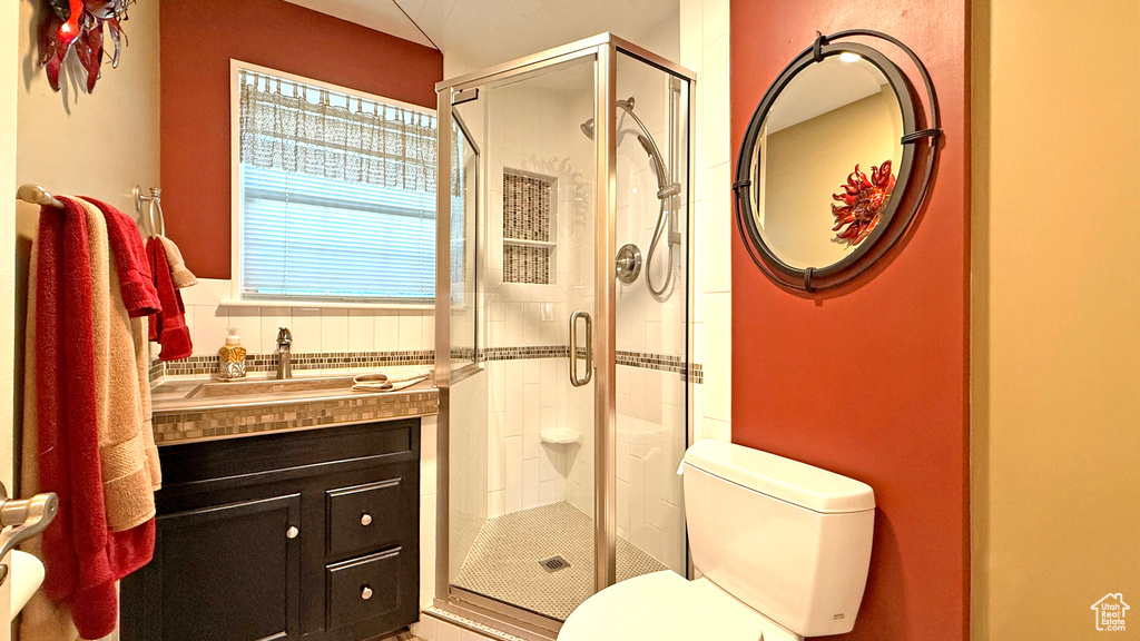 Full bath with a shower stall and vanity