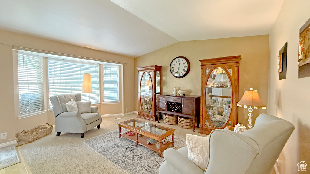 Living area with vaulted ceiling and carpet flooring