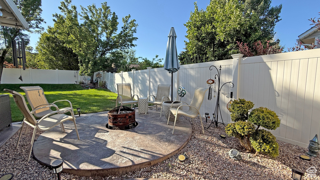 Fenced backyard with a patio and a fire pit