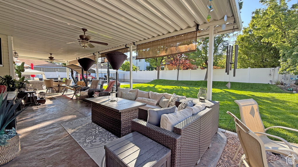 Fenced backyard featuring an outdoor hangout area, ceiling fan, outdoor dining area, and a patio