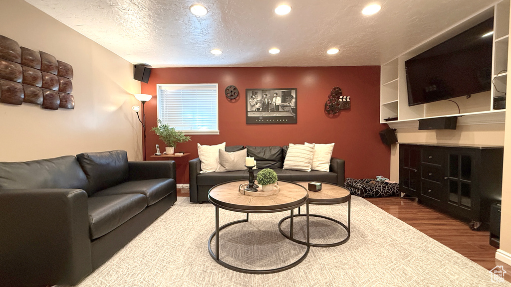 Living area with wood finished floors, recessed lighting, and a textured ceiling