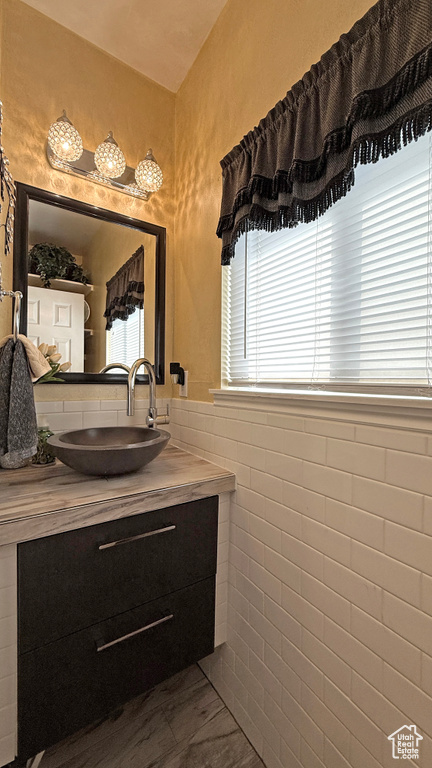 Bathroom with vanity and tile walls