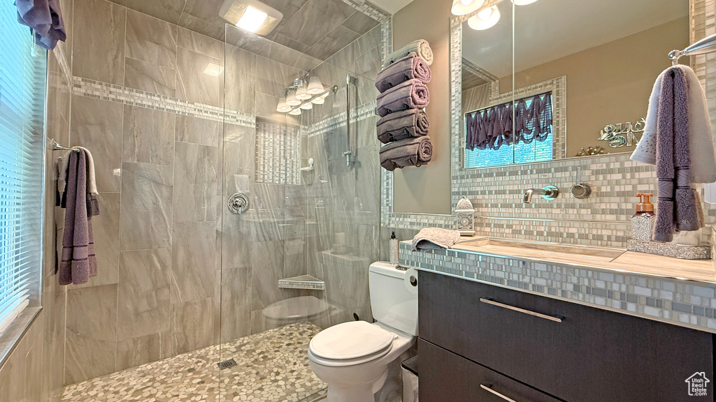 Bathroom with tile walls, vanity, and tiled shower