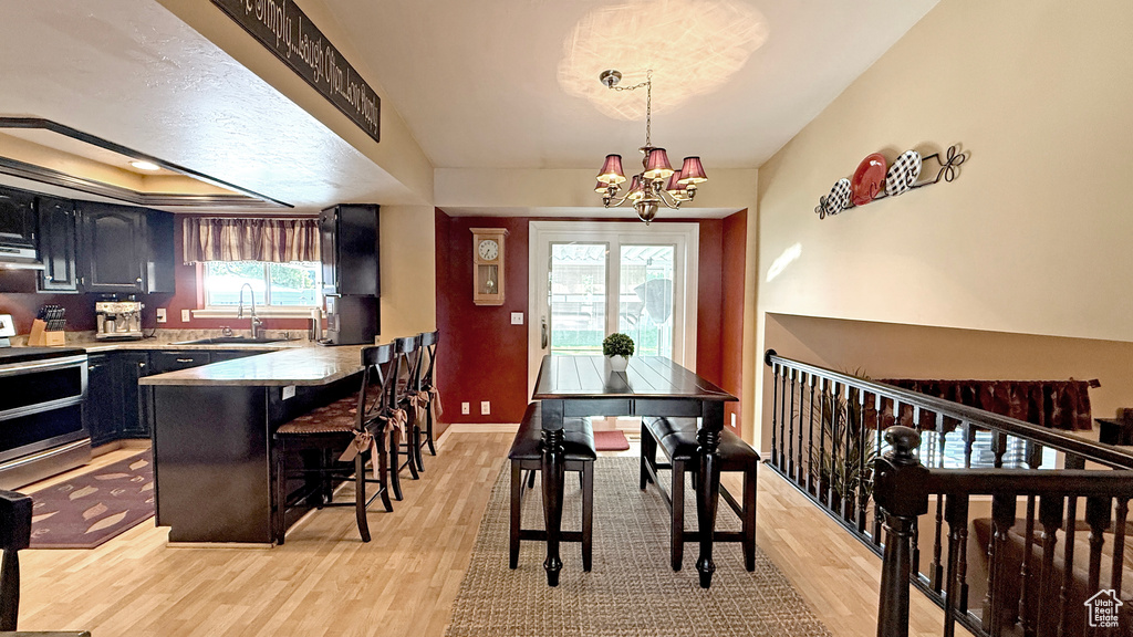 Dining room with light wood-type flooring and a chandelier