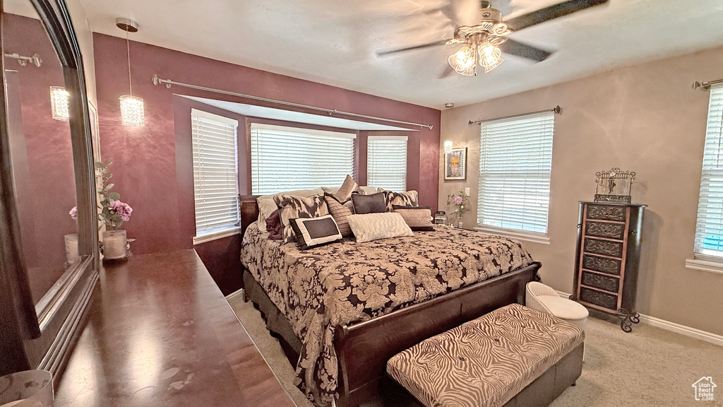 Bedroom with multiple windows, a ceiling fan, and carpet flooring