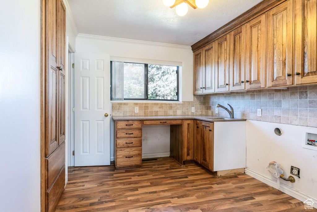 Washroom with hookup for a washing machine, crown molding, dark wood-style floors, cabinet space, and hookup for a gas dryer