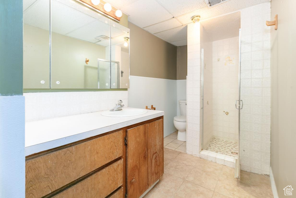 Full bathroom featuring vanity, a stall shower, tile patterned flooring, and decorative backsplash