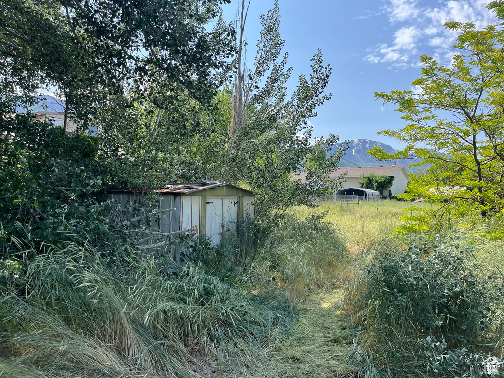 View of property exterior with a storage unit and a mountain view