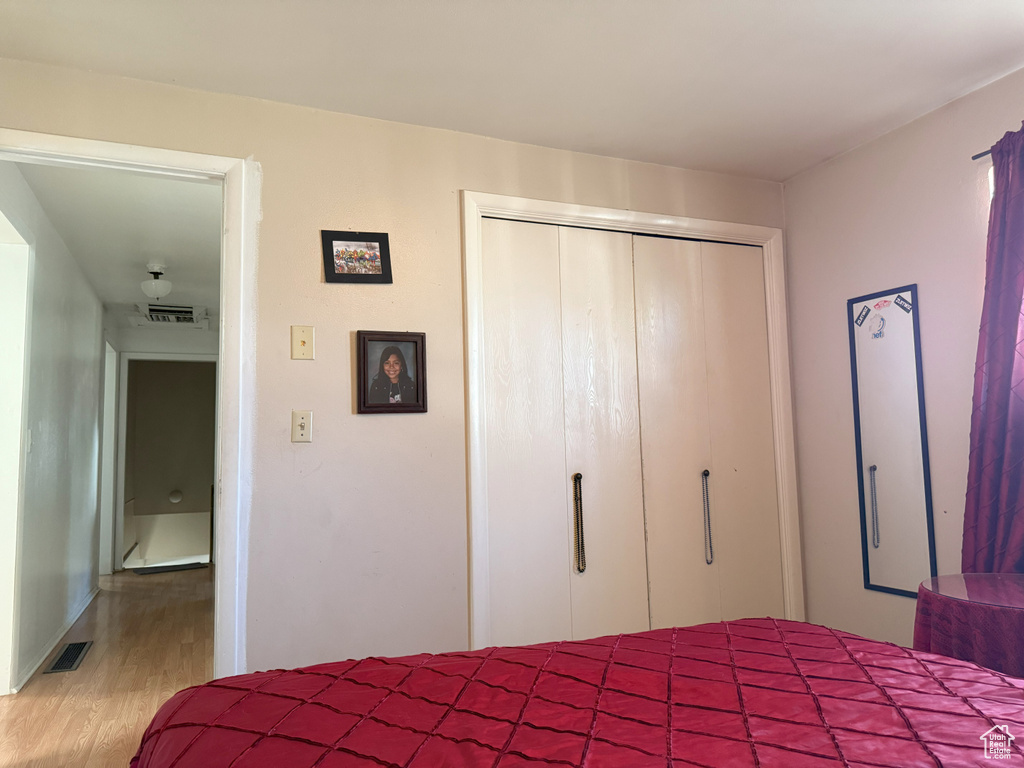 Bedroom featuring wood finished floors and a closet