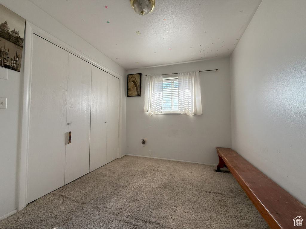 Unfurnished bedroom with carpet and a closet
