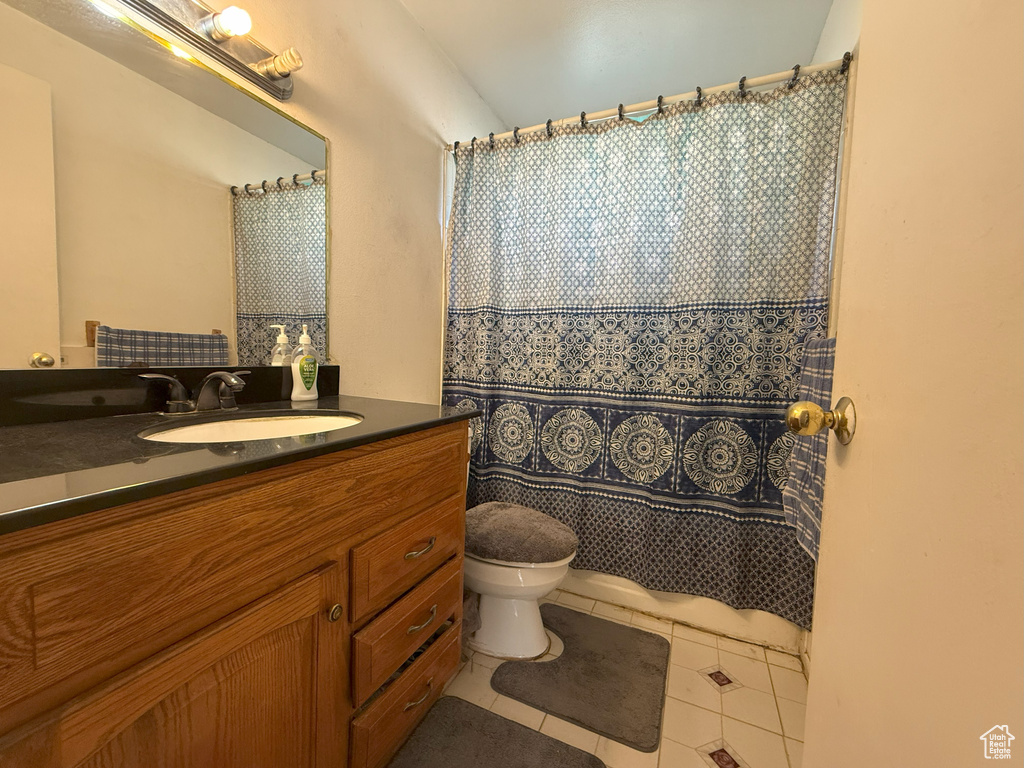 Full bathroom with vanity, tile patterned flooring, and a shower with shower curtain