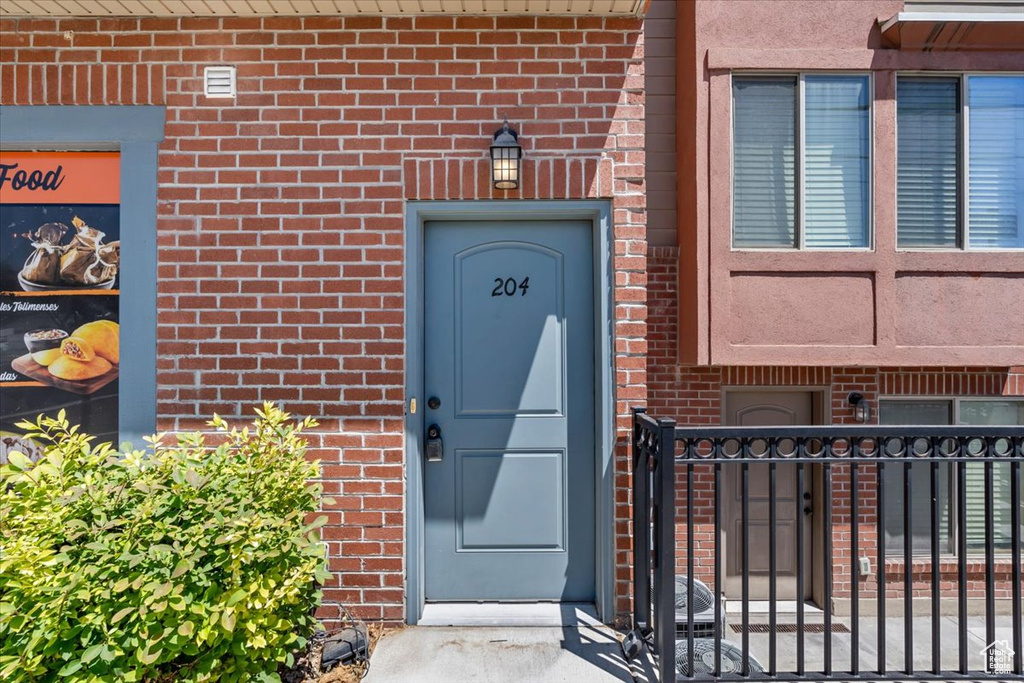 Doorway to property with brick siding and a gate