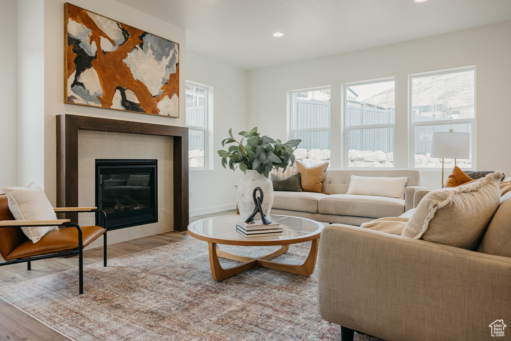 Living area featuring wood finished floors, a tile fireplace, and recessed lighting