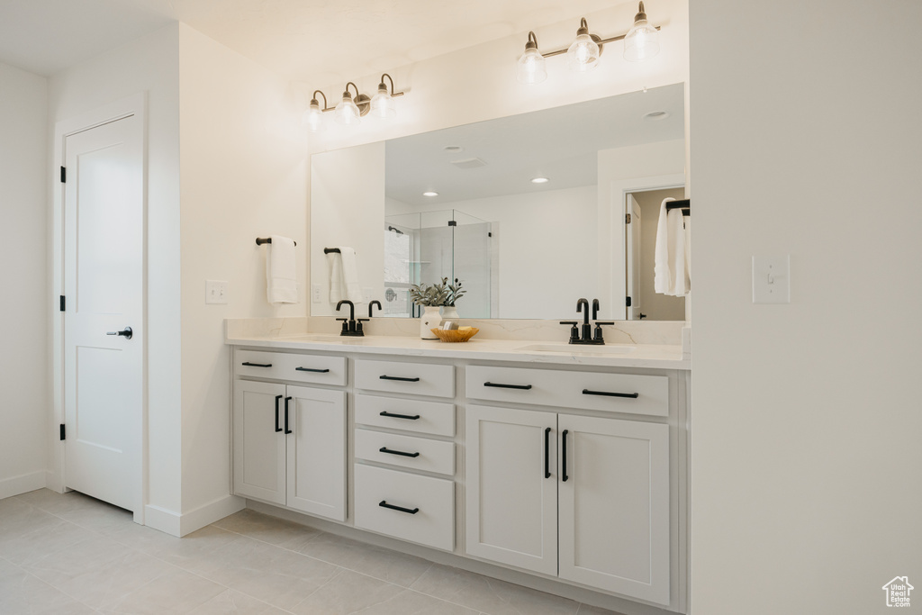 Full bathroom with double vanity, a stall shower, tile patterned flooring, and recessed lighting