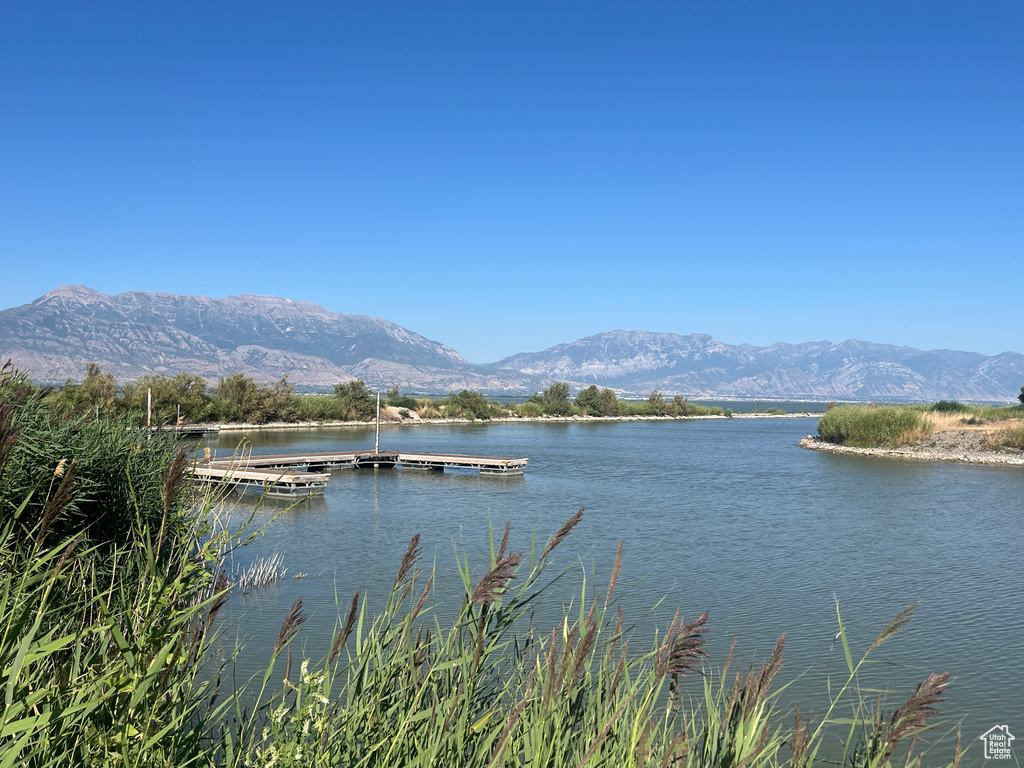 Water view featuring a mountainous background and a floating dock