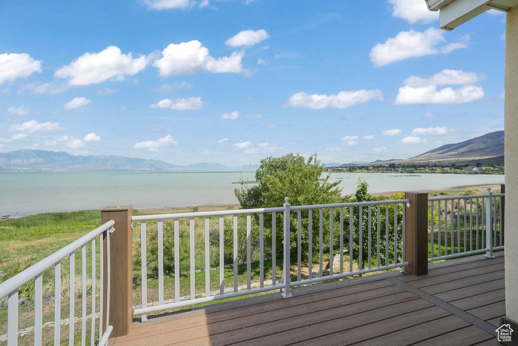 Wooden terrace featuring a water and mountain view