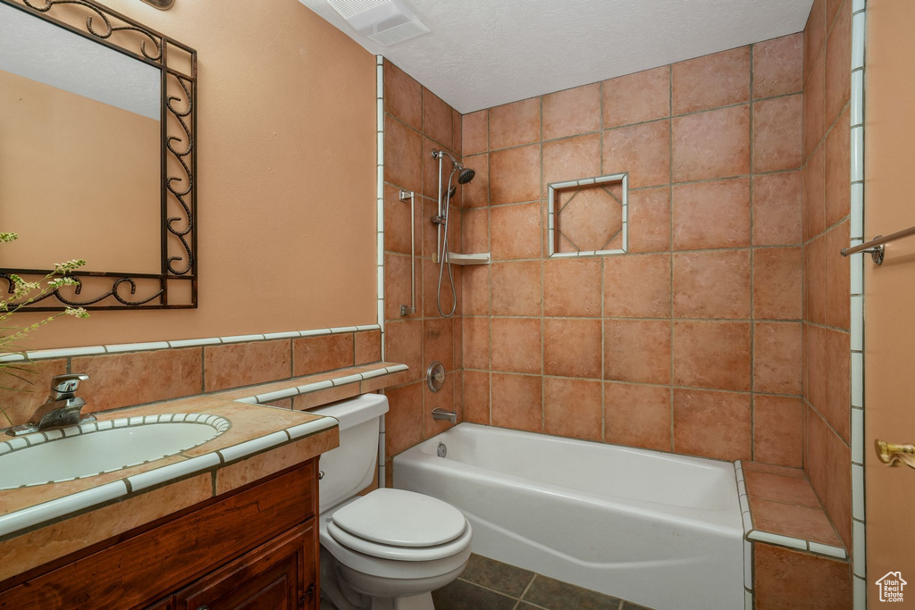 Bathroom featuring vanity, shower / bath combination, tile walls, and tile patterned floors