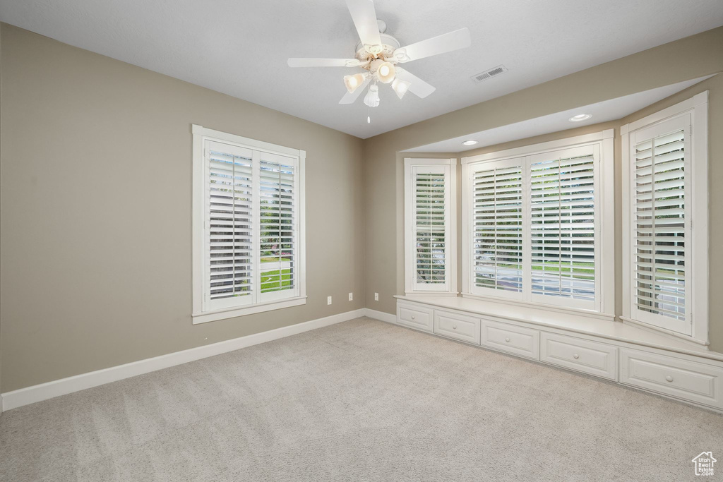 Carpeted empty room with ceiling fan and recessed lighting