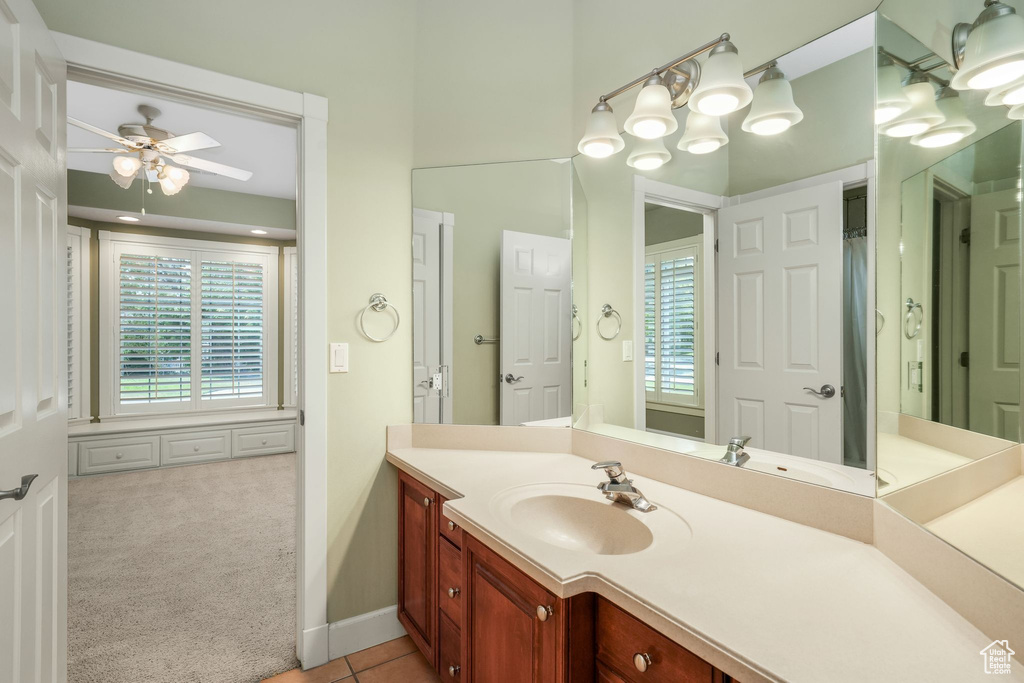 Full bath with ceiling fan, vanity, and tile patterned flooring